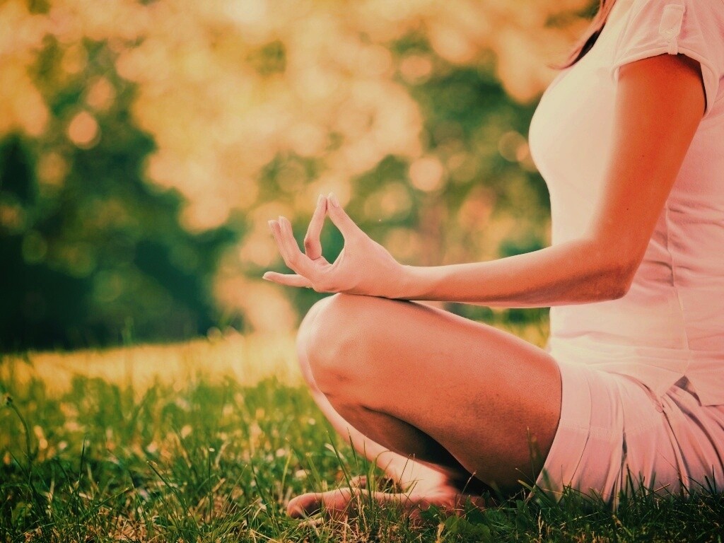 Девушка медитирует в позе лотоса на траве обои