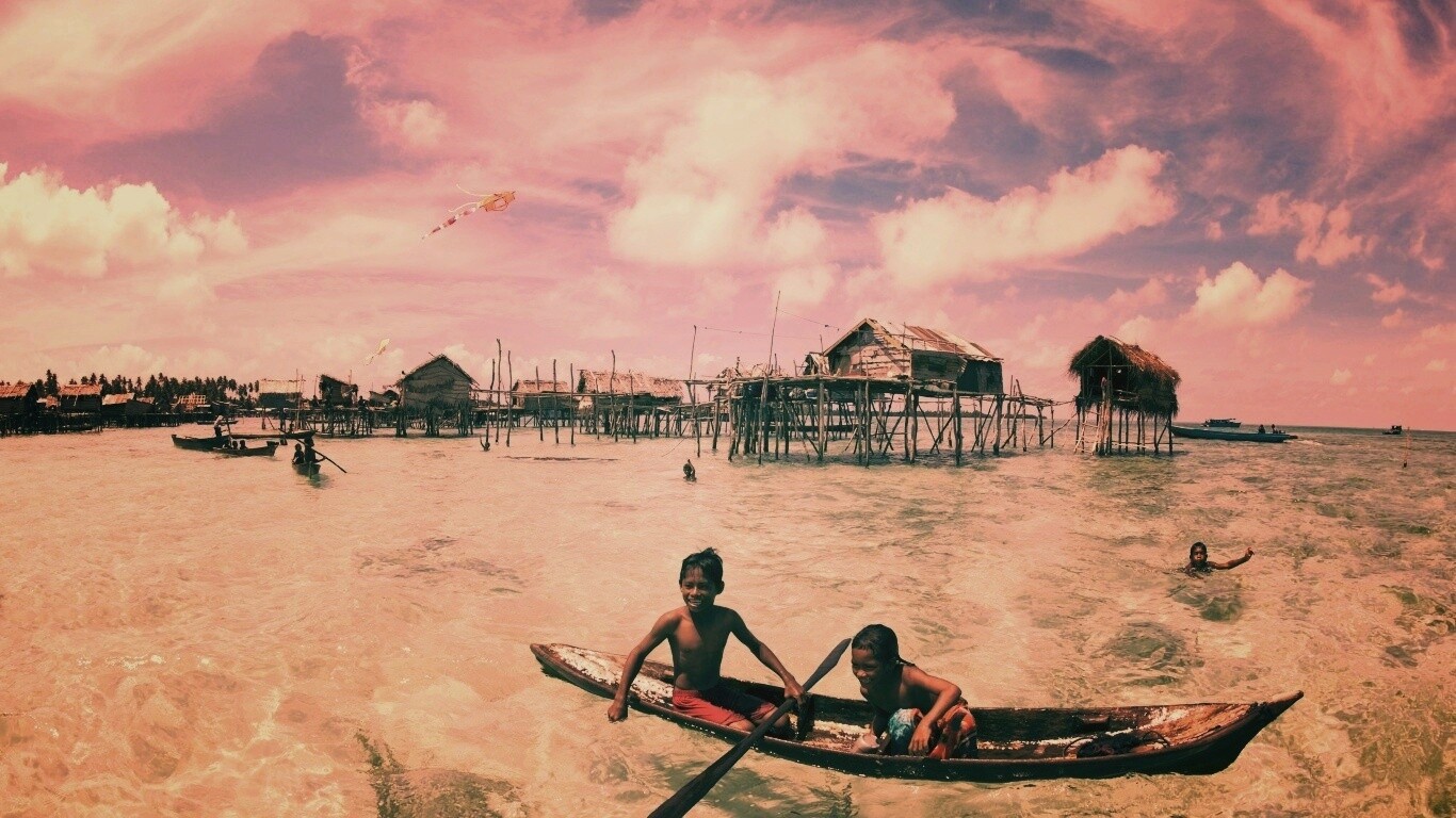 Дети в лодке у поселения туземцев обои