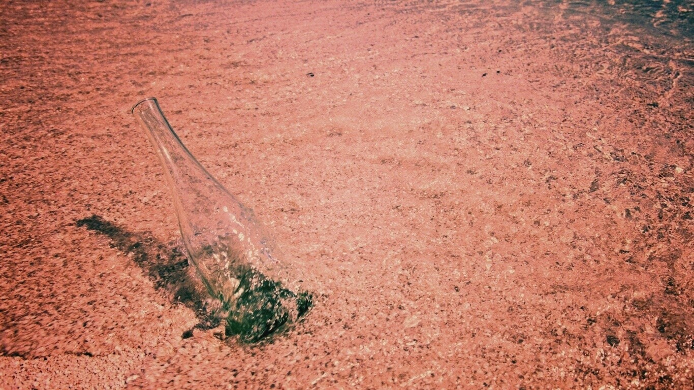 Бутылка в песке у воды обои