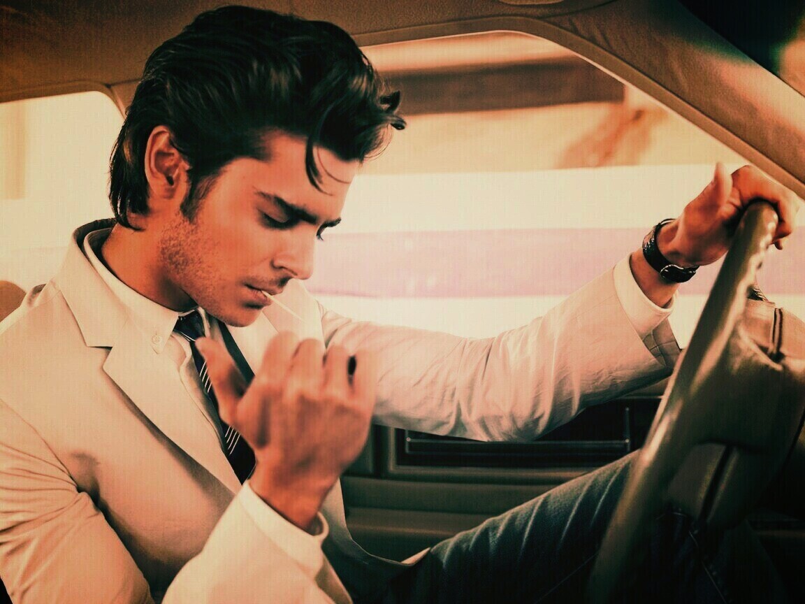 Мужчина прикуривает в машине обои