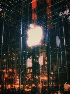 Отражение логотипа Apple в стеклянном здании обои