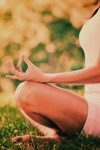 Девушка медитирует в позе лотоса на траве обои