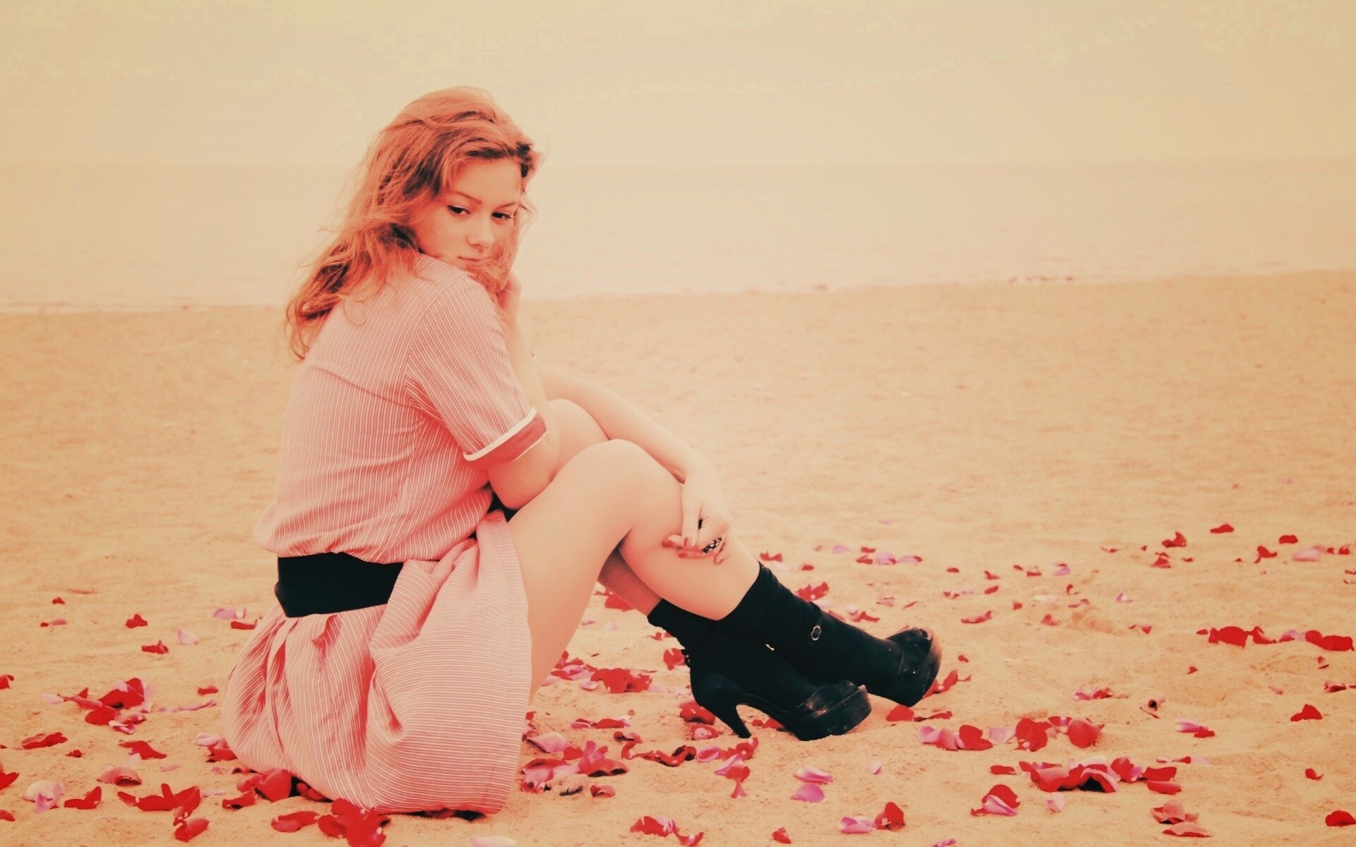 Девушка среди лепестков на пляже обои
