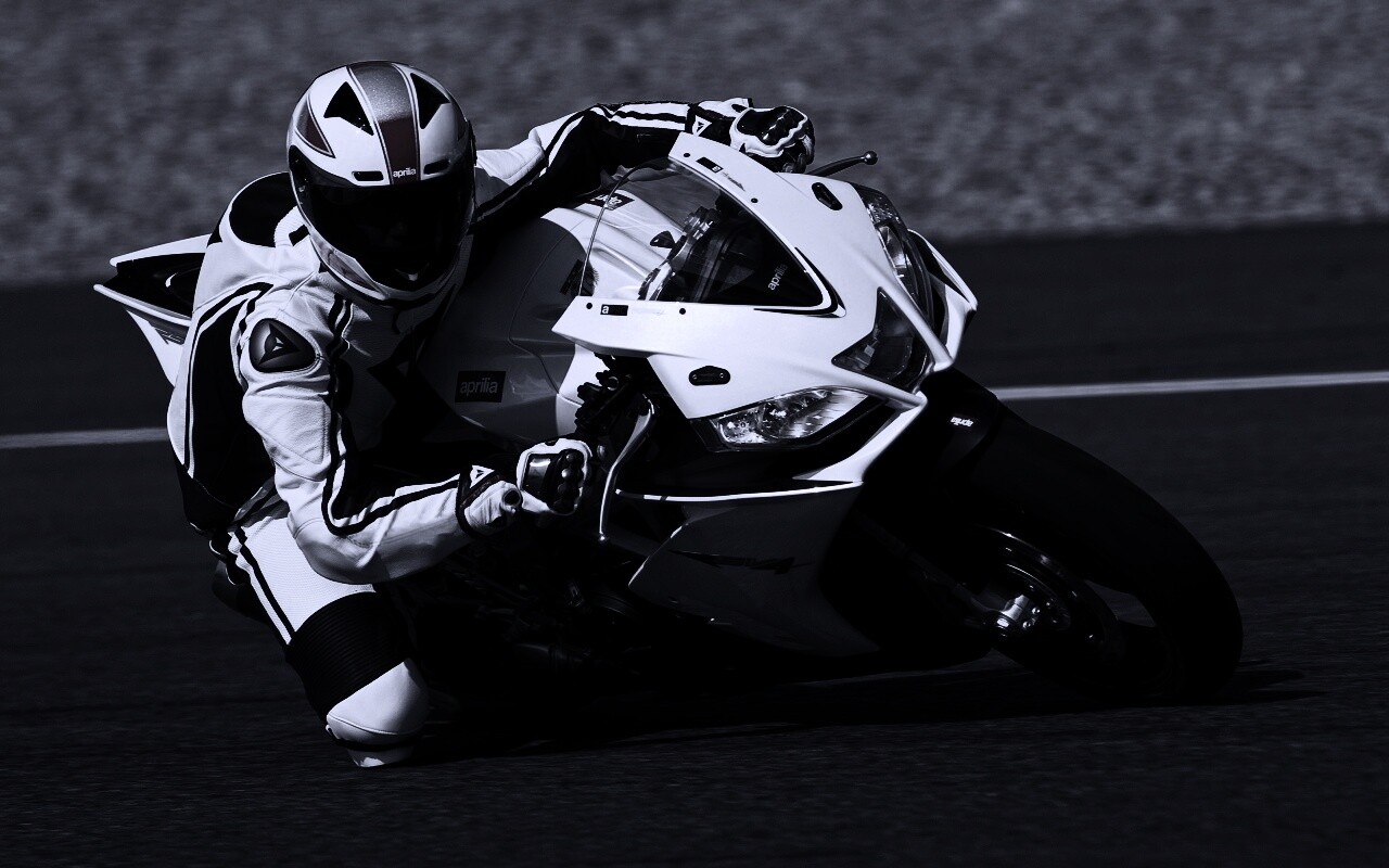 Байкер в белой экиперовкена Априлия РСВ4 обои