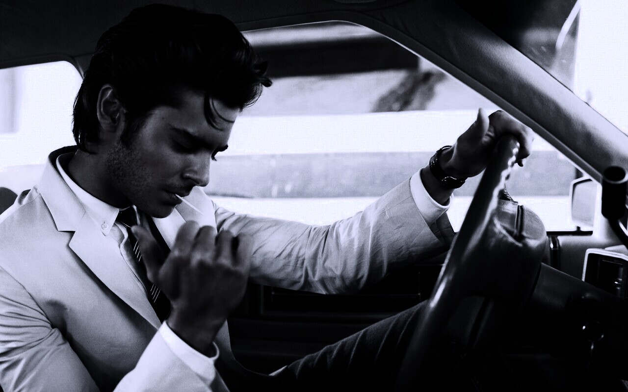 Мужчина прикуривает в машине обои