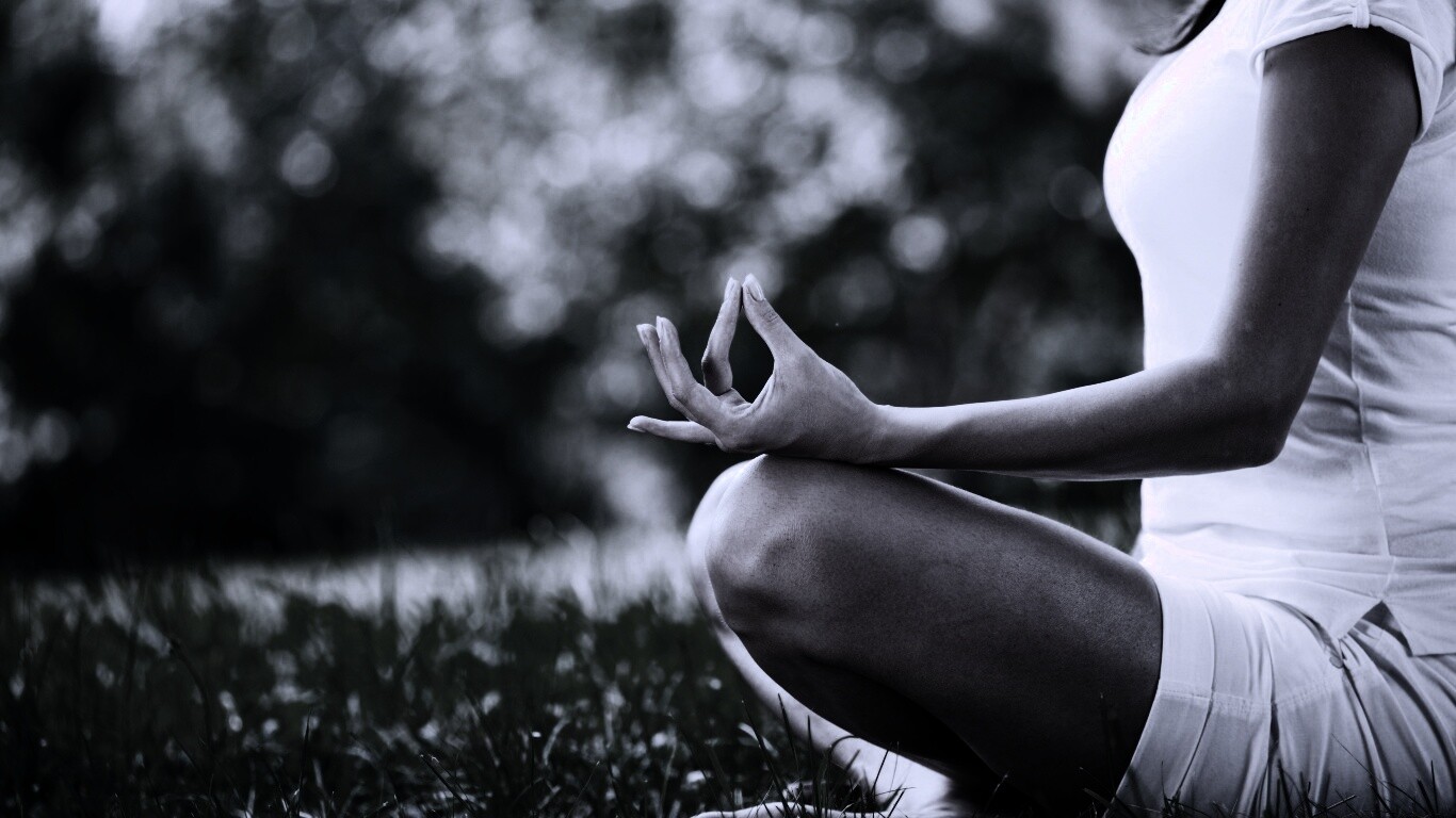 Девушка медитирует в позе лотоса на траве обои