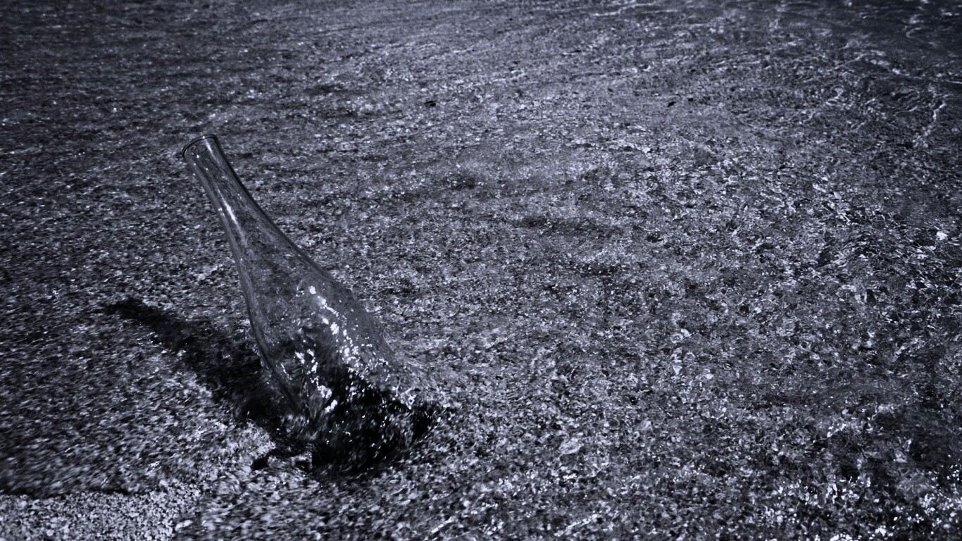 Бутылка в песке у воды обои