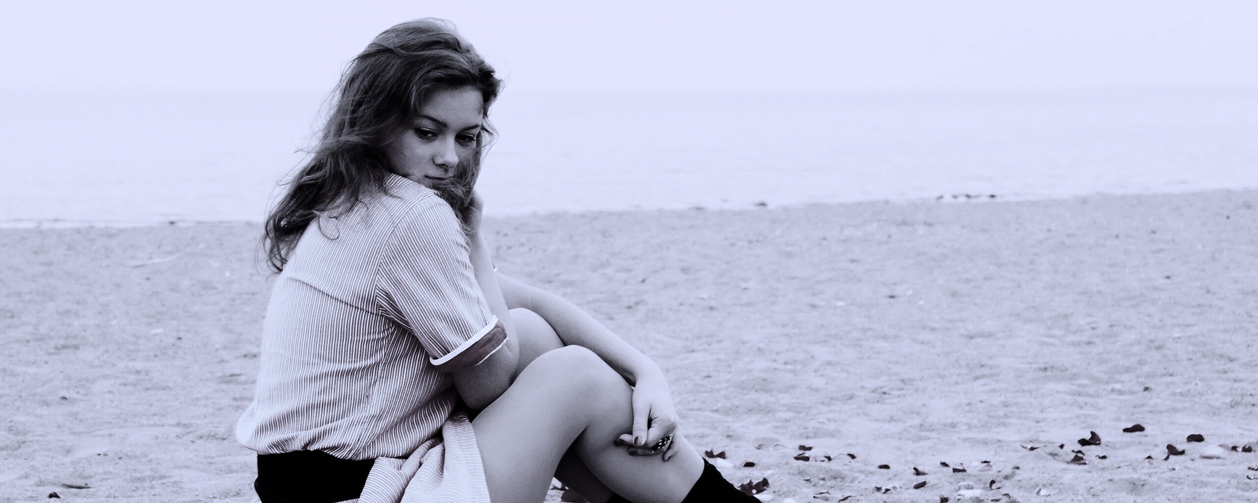 Девушка среди лепестков на пляже обои