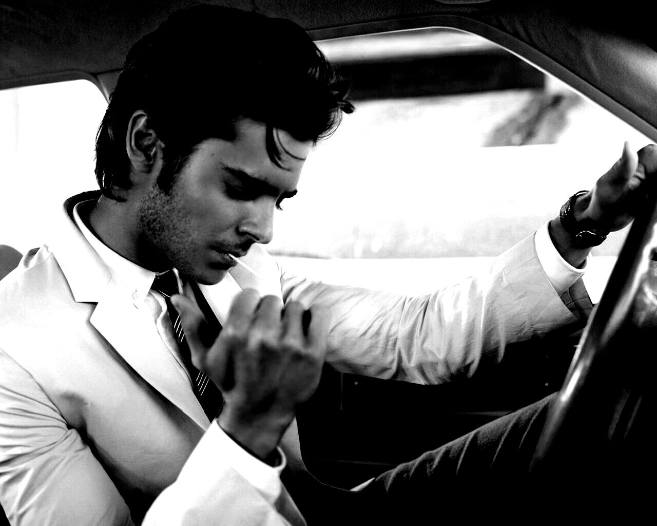 Мужчина прикуривает в машине обои