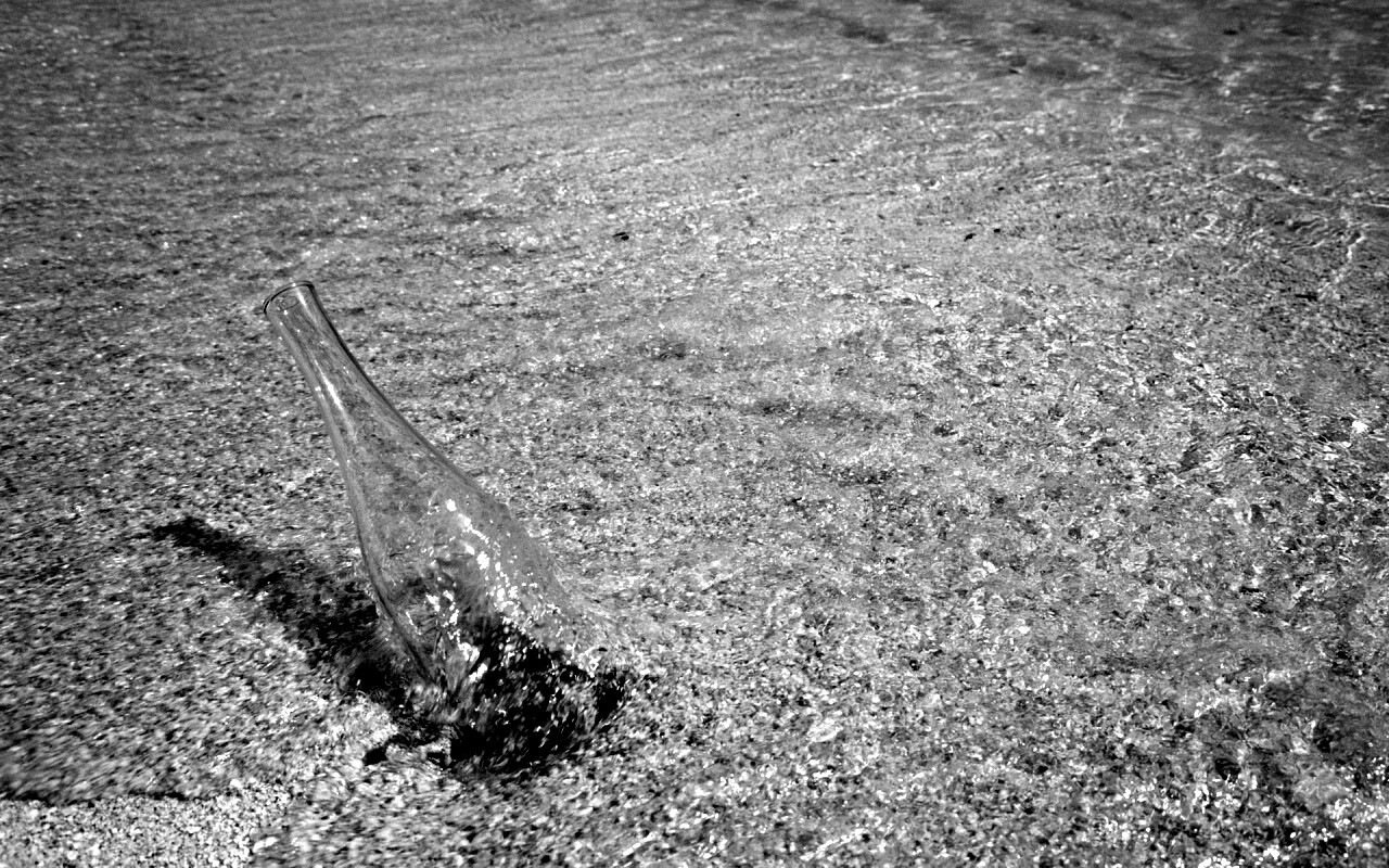 Бутылка в песке у воды обои