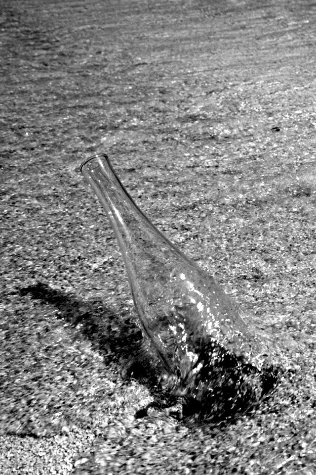 Бутылка в песке у воды обои