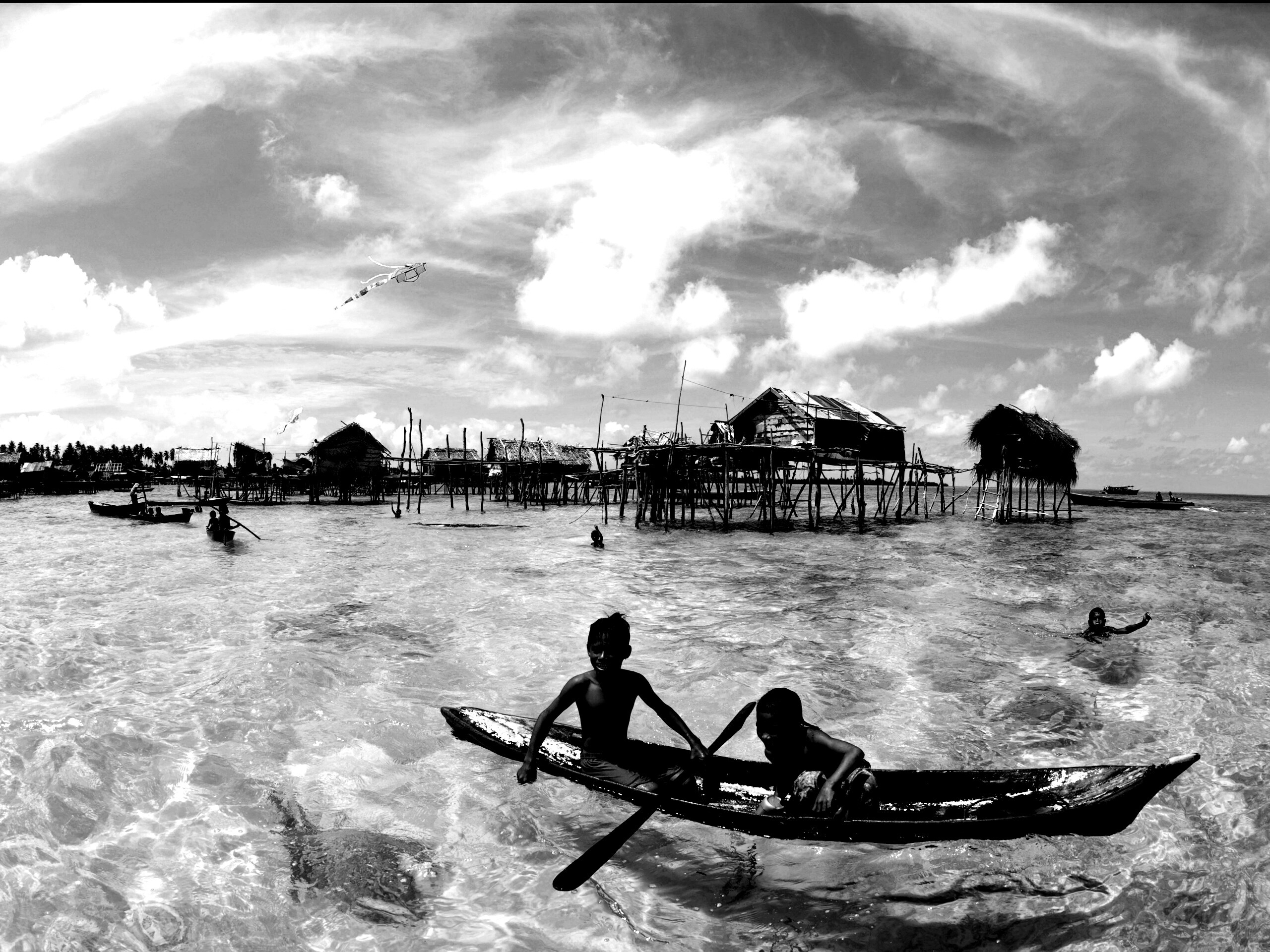 Дети в лодке у поселения туземцев обои