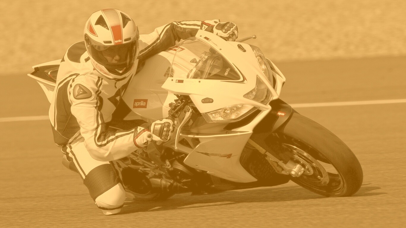 Байкер в белой экиперовкена Априлия РСВ4 обои