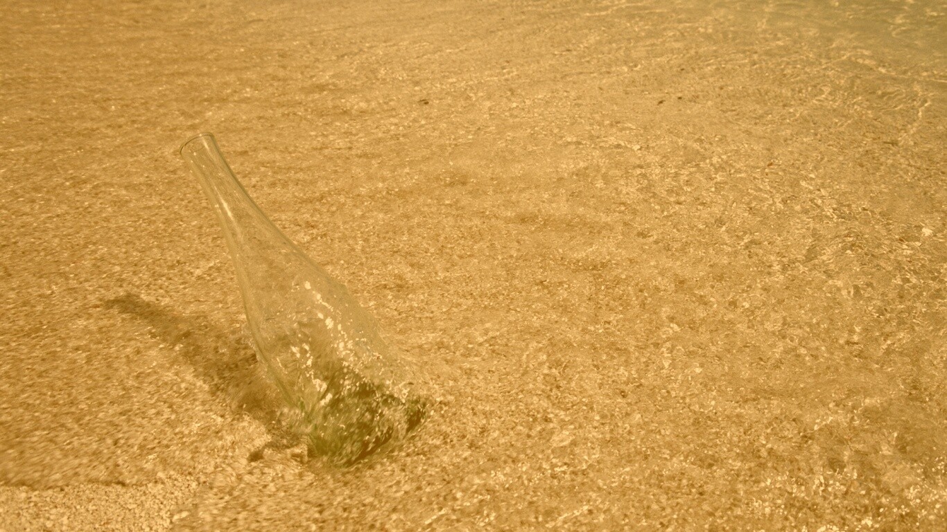 Бутылка в песке у воды обои