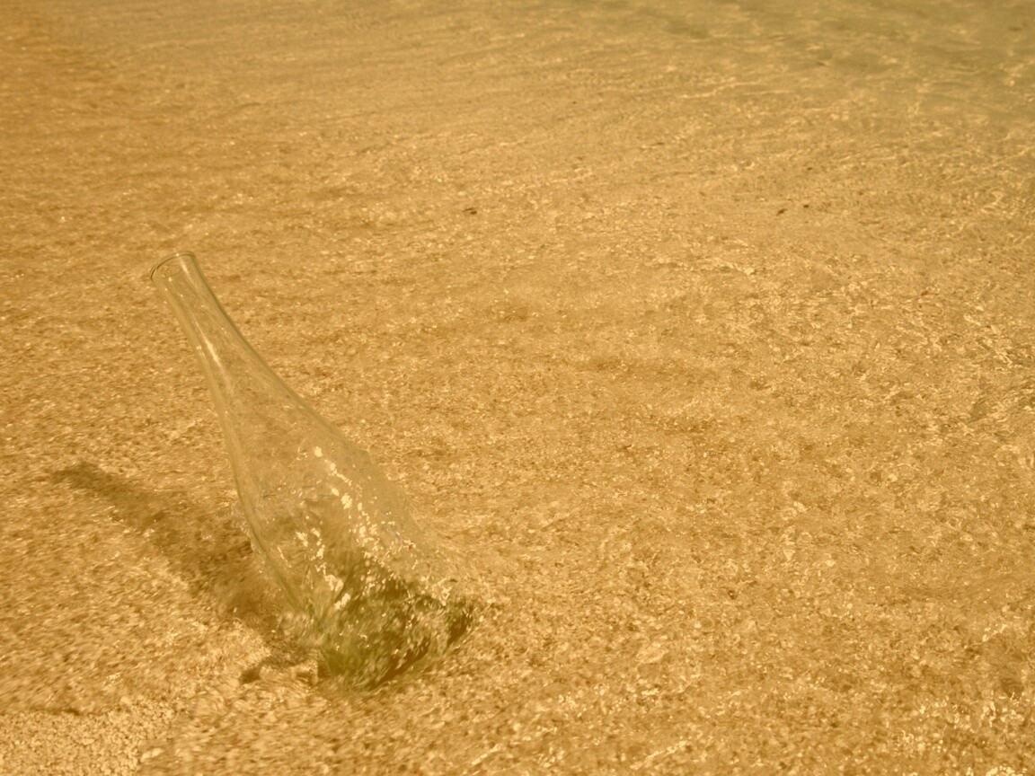 Бутылка в песке у воды обои