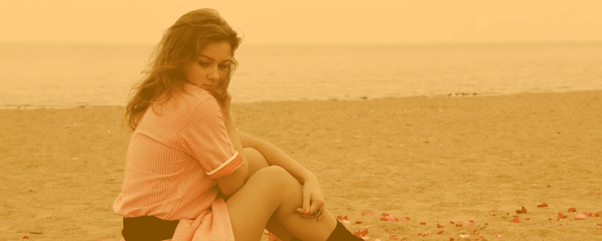 Девушка среди лепестков на пляже обои