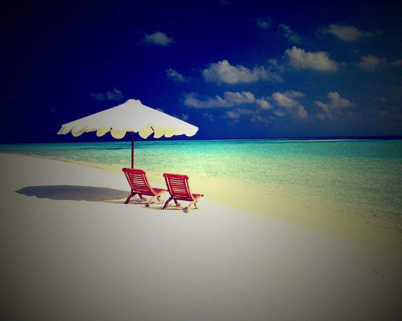 Песчаный пляж с двумя жезлонгами обои