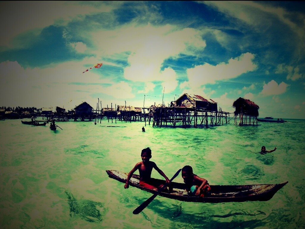 Дети в лодке у поселения туземцев обои