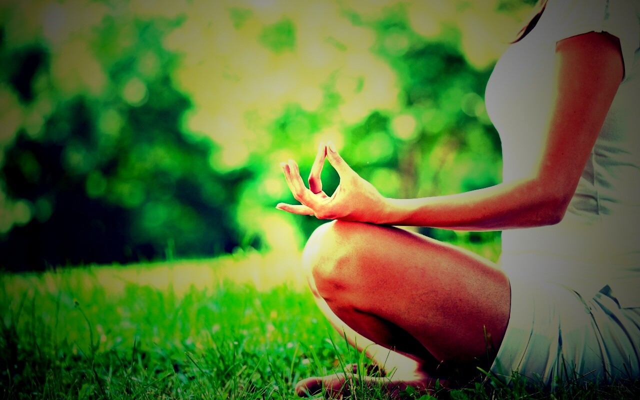 Девушка медитирует в позе лотоса на траве обои