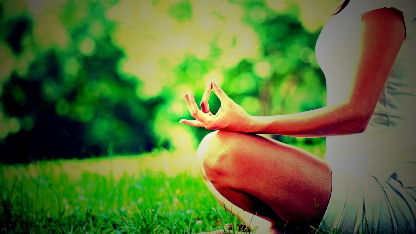 Девушка медитирует в позе лотоса на траве обои