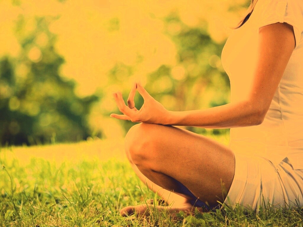 Девушка медитирует в позе лотоса на траве обои