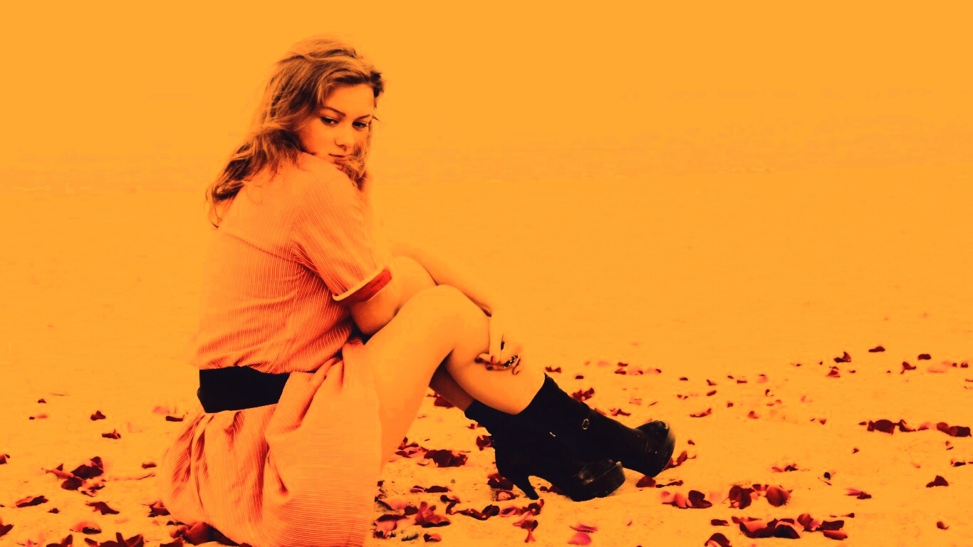 Девушка среди лепестков на пляже обои