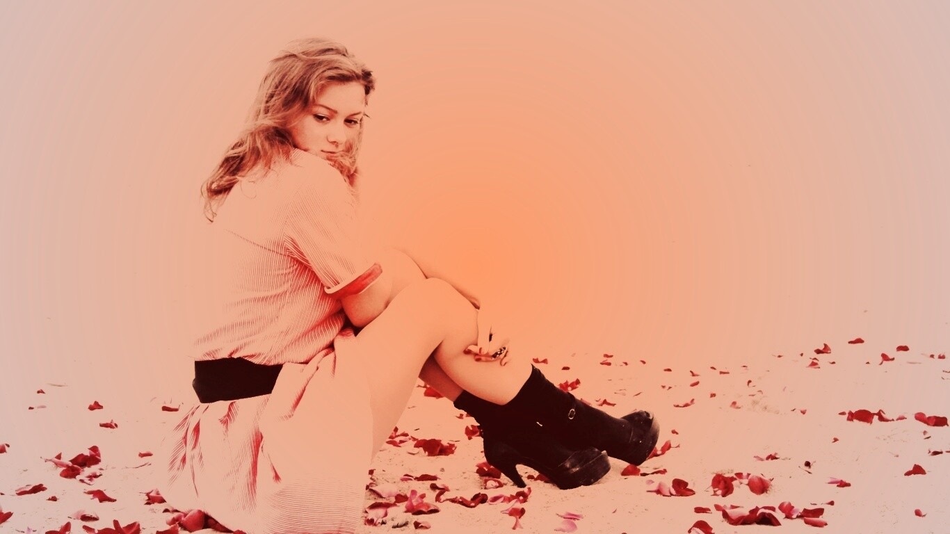 Девушка среди лепестков на пляже обои