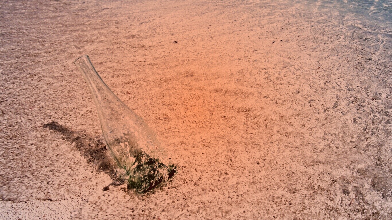 Бутылка в песке у воды обои
