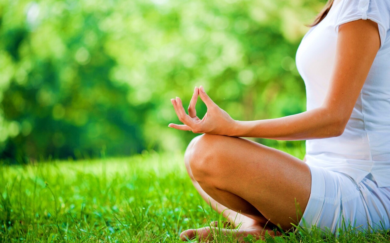 Девушка медитирует в позе лотоса на траве обои