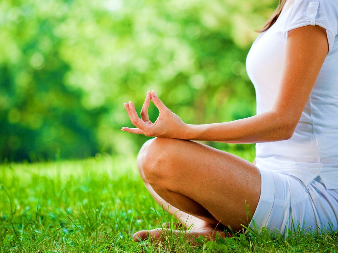 Девушка медитирует в позе лотоса на траве обои