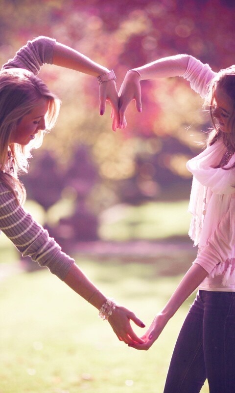 Две девушки и сердце из рук обои