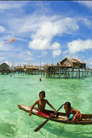 Дети в лодке у поселения туземцев обои