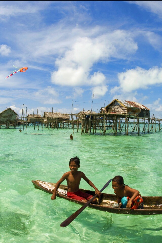 Дети в лодке у поселения туземцев обои
