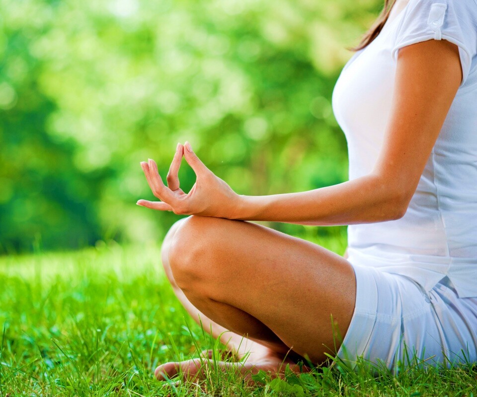 Девушка медитирует в позе лотоса на траве обои