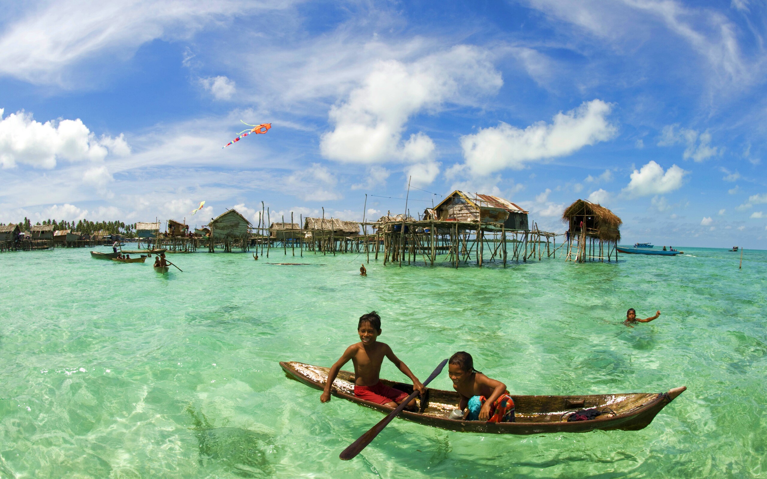 Дети в лодке у поселения туземцев обои