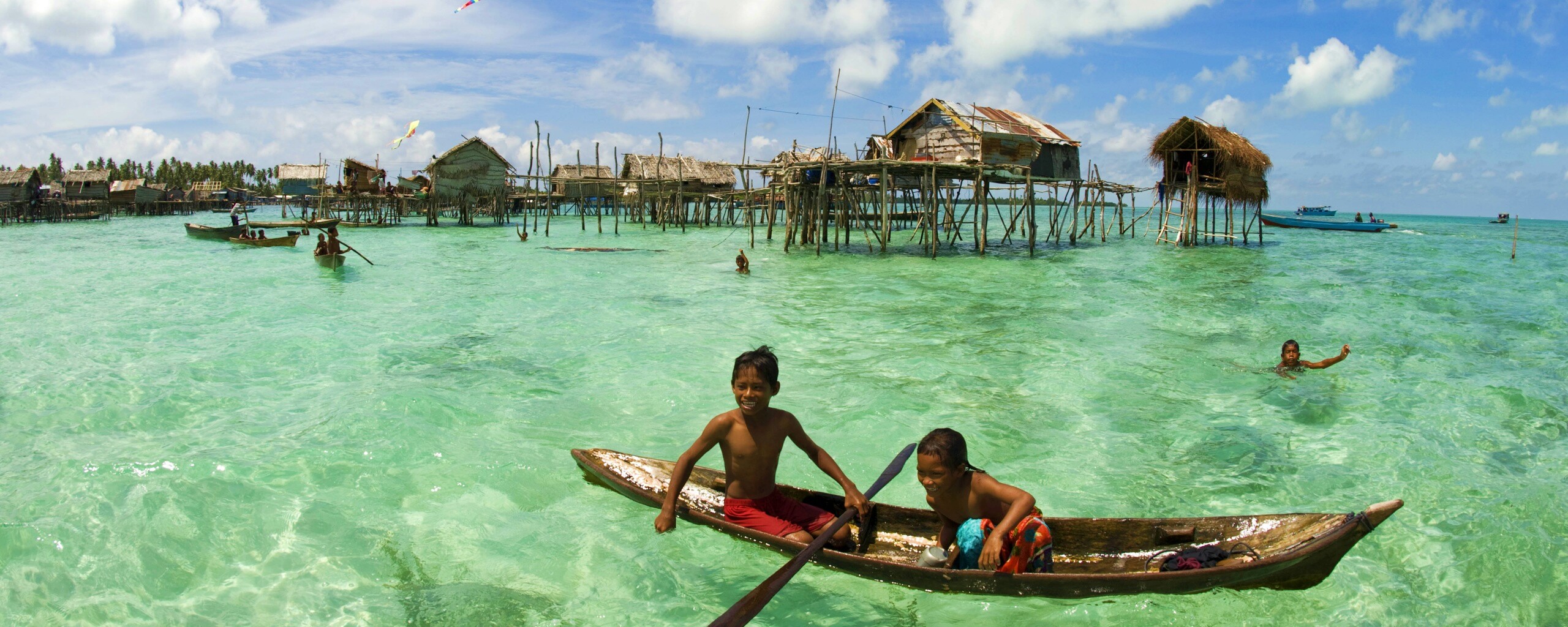 Дети в лодке у поселения туземцев обои