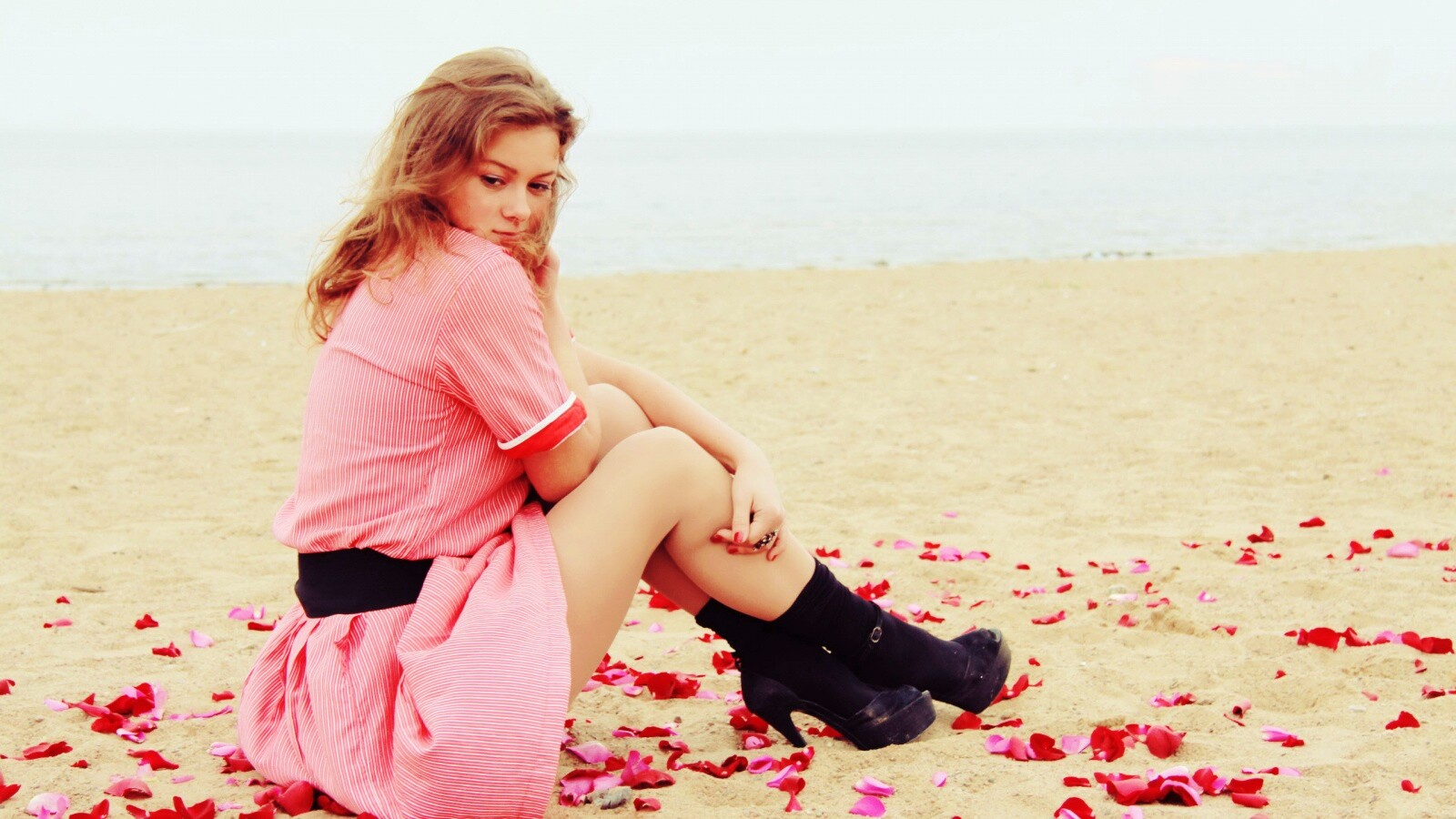 Девушка среди лепестков на пляже обои