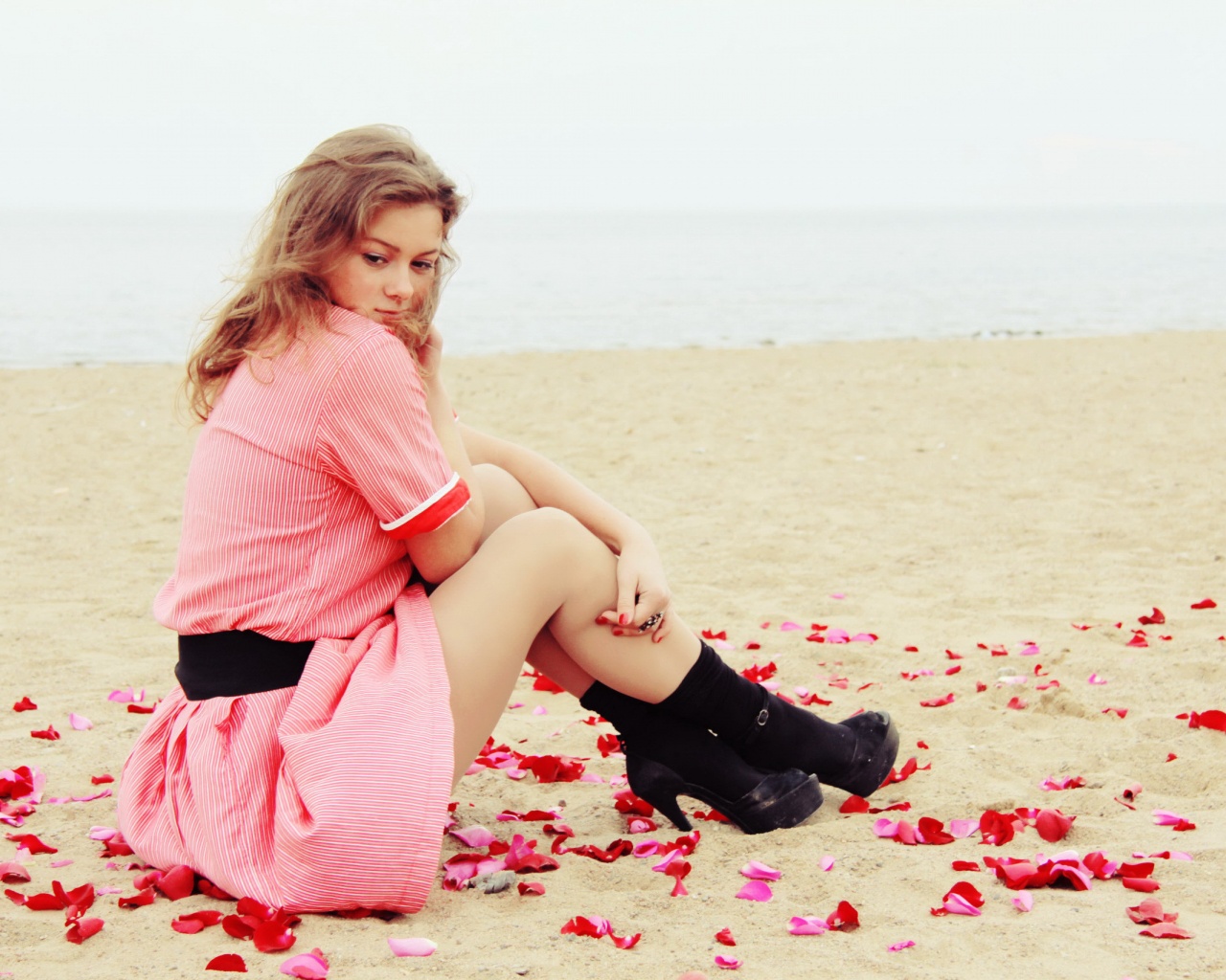Девушка среди лепестков на пляже обои