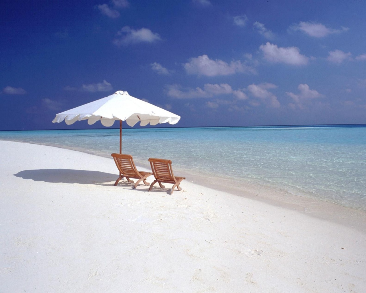 Песчаный пляж с двумя жезлонгами обои