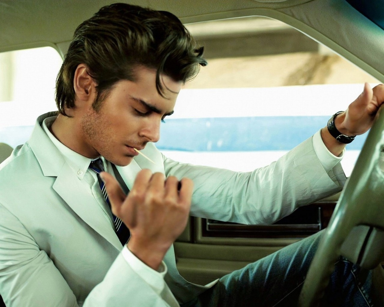 Мужчина прикуривает в машине обои