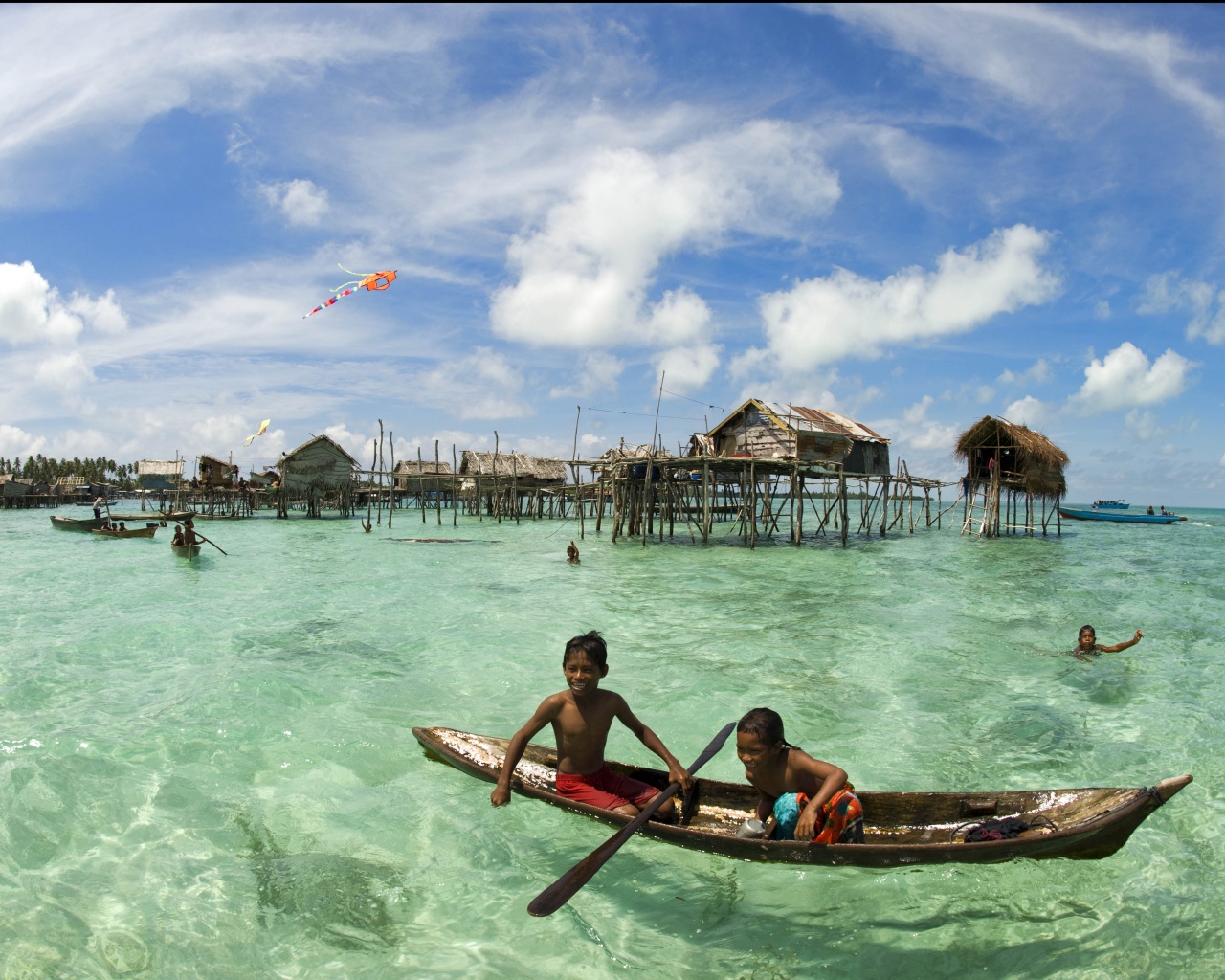 Дети в лодке у поселения туземцев обои