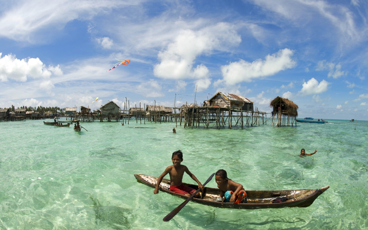 Дети в лодке у поселения туземцев обои