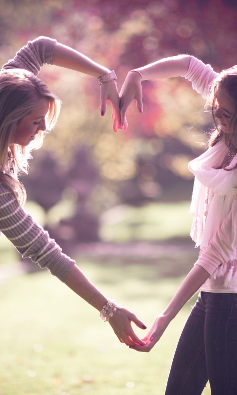 Две девушки и сердце из рук обои