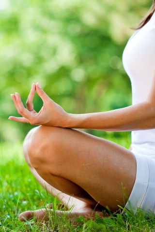 Девушка медитирует в позе лотоса на траве обои