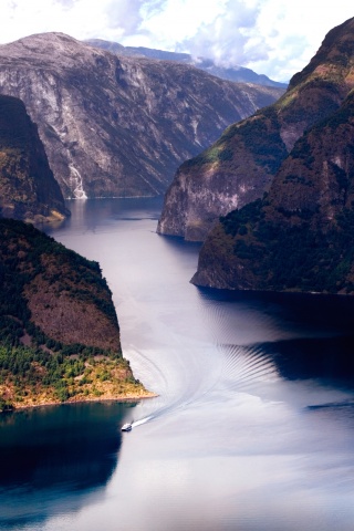 Лодка на реке среди высоких гор обои