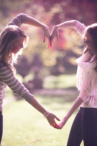 Две девушки и сердце из рук обои