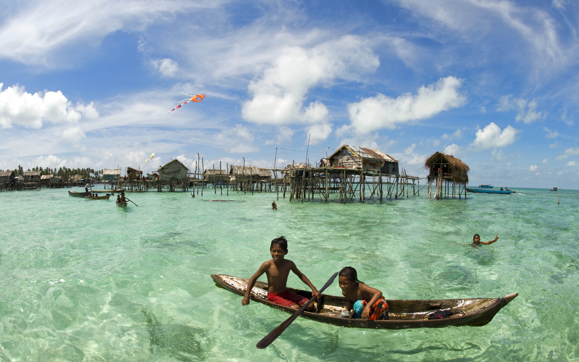 Дети в лодке у поселения туземцев обои