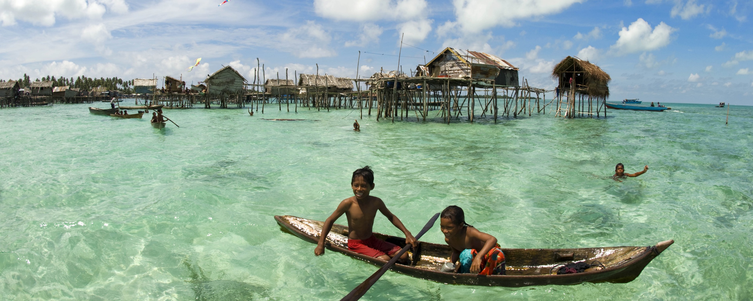 Дети в лодке у поселения туземцев обои