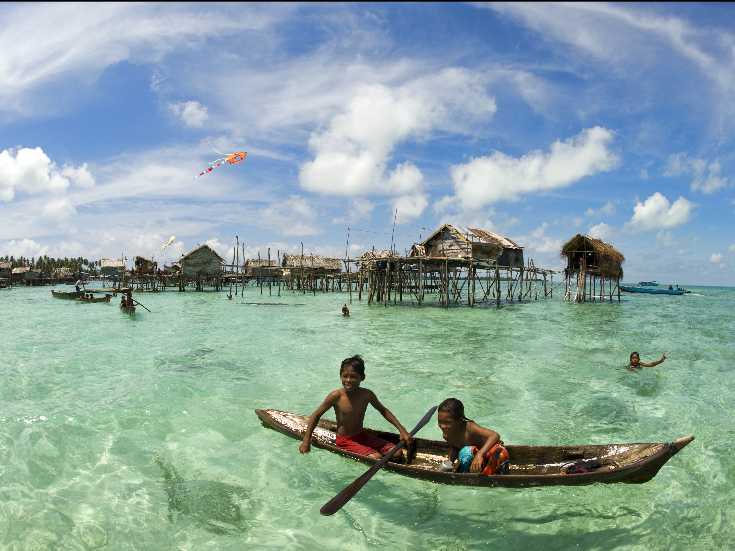 Дети в лодке у поселения туземцев обои